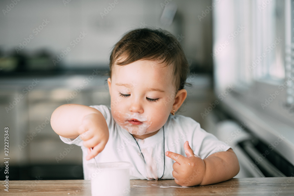 A little charming girl eats yogurt all smeared herself A little charming girl eats yogurt all smeared herself