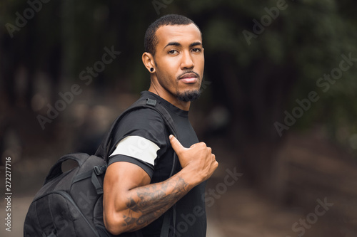 African-American Man Wearing Black T-Shirt And Backpack