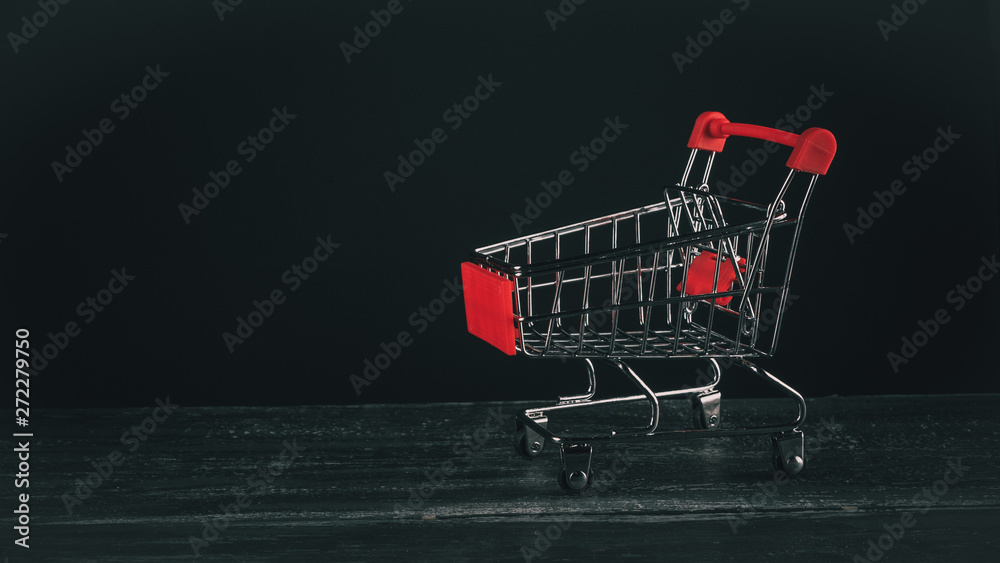 empty mini shopping trolley on a dark background