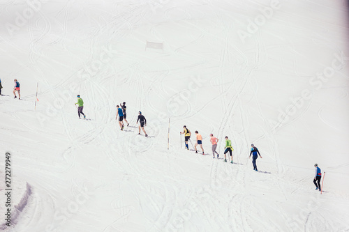 Unidentified people walk along the slope at a ski resort during an active holiday. Trekking and skiing concept. Copyspace