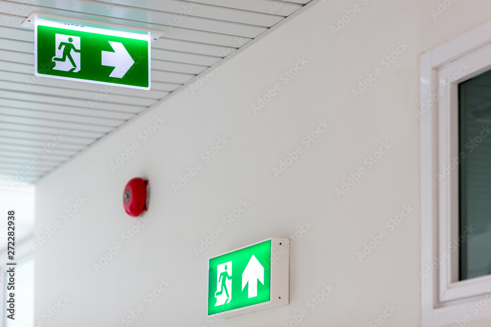 Green emergency exit sign showing the way to escape.Fire exit in the building. Green emergency exit sign showing the way to escape.Fire exit in the building.