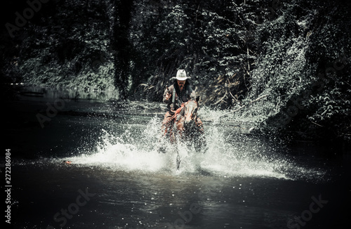 Cowboy on horseback.Cowboy riding horse and running on river.