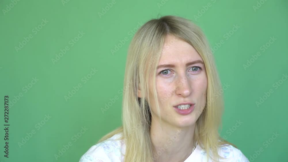 Young beautiful woman crying on green background. Hysterics. She speake Young beautiful woman crying on green background. Hysterics. She speake