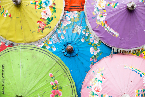 yellow up left green down left purple up right pink down right and blue in middle of traditional Thailand umbrella stock photo
