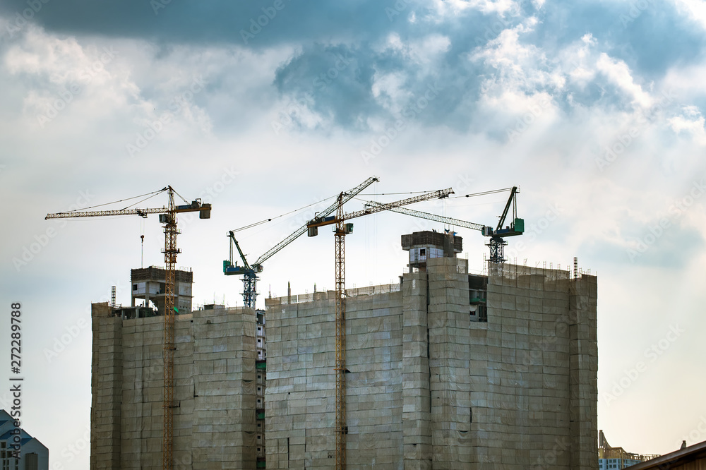 Construction cranes and buildings are under construction.