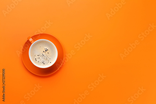 Orange coffee cup over orange background photo