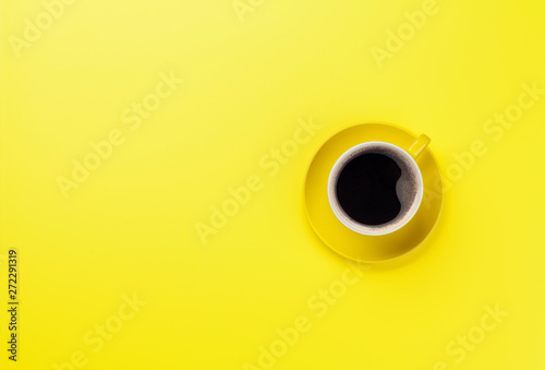 Yellow coffee cup over yellow background