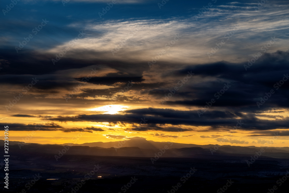 Golden sunrise with rays through clouds across southern Utah