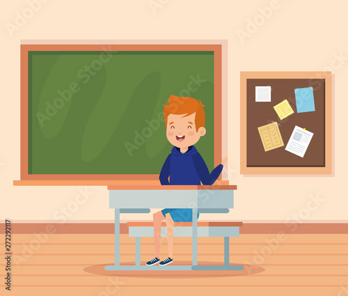 boy child in the classroom with desk and blackboard