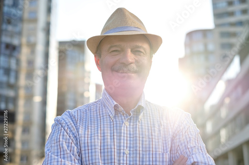 Senior hispanic man in hispanic hat with mustache looking at camera smiling in city centre. Horizontal shape © Viktor Koldunov