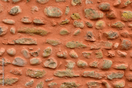 Mur de pierres et galets avec enduit rose