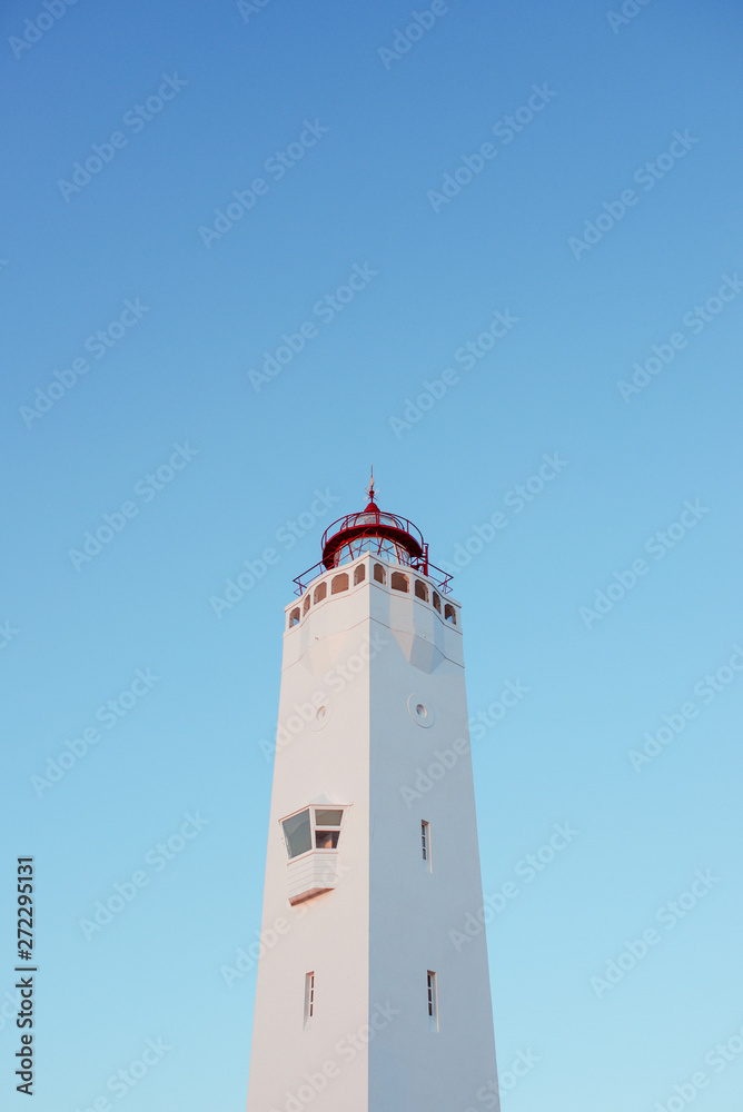 white lighthouse on blue sky background near the sea 