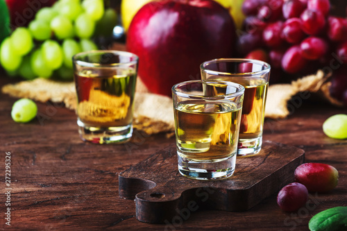 Rakija, raki or rakia - Balkan strong alcoholic drink brandy type based on fermented fruits, vintage wooden table, still life in rustic style, place for text photo