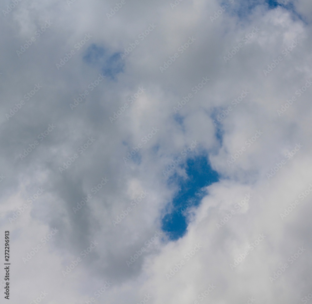 Obraz premium The white clouds with a patch of blue in the sky.