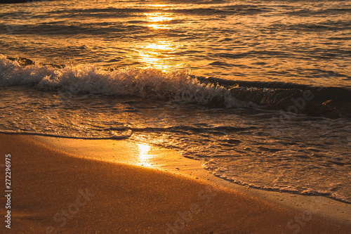 Fototapeta Naklejka Na Ścianę i Meble -  Waves lapping on a sandy beach at sunset