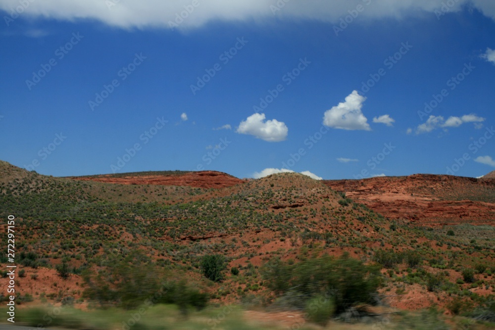 USA.  Red mountains Utah. Gray Mountains in Utah. View from the highway from car. Spring, fine weather. Grass on the rocks