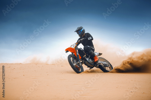Fotografie Rider on a cross-country enduro motorcycle go fast at the desert