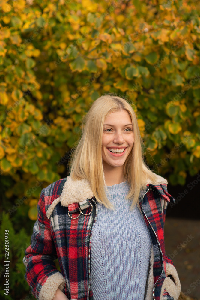 Smiling young woman in park. Trees with yellow leaves. Cozy autumn. Hugge soft concept. Smiling young woman in park. Trees with yellow leaves. Cozy autumn. Hugge soft concept.