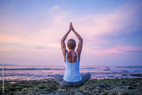 Caucasian woman practicing yoga at seashore