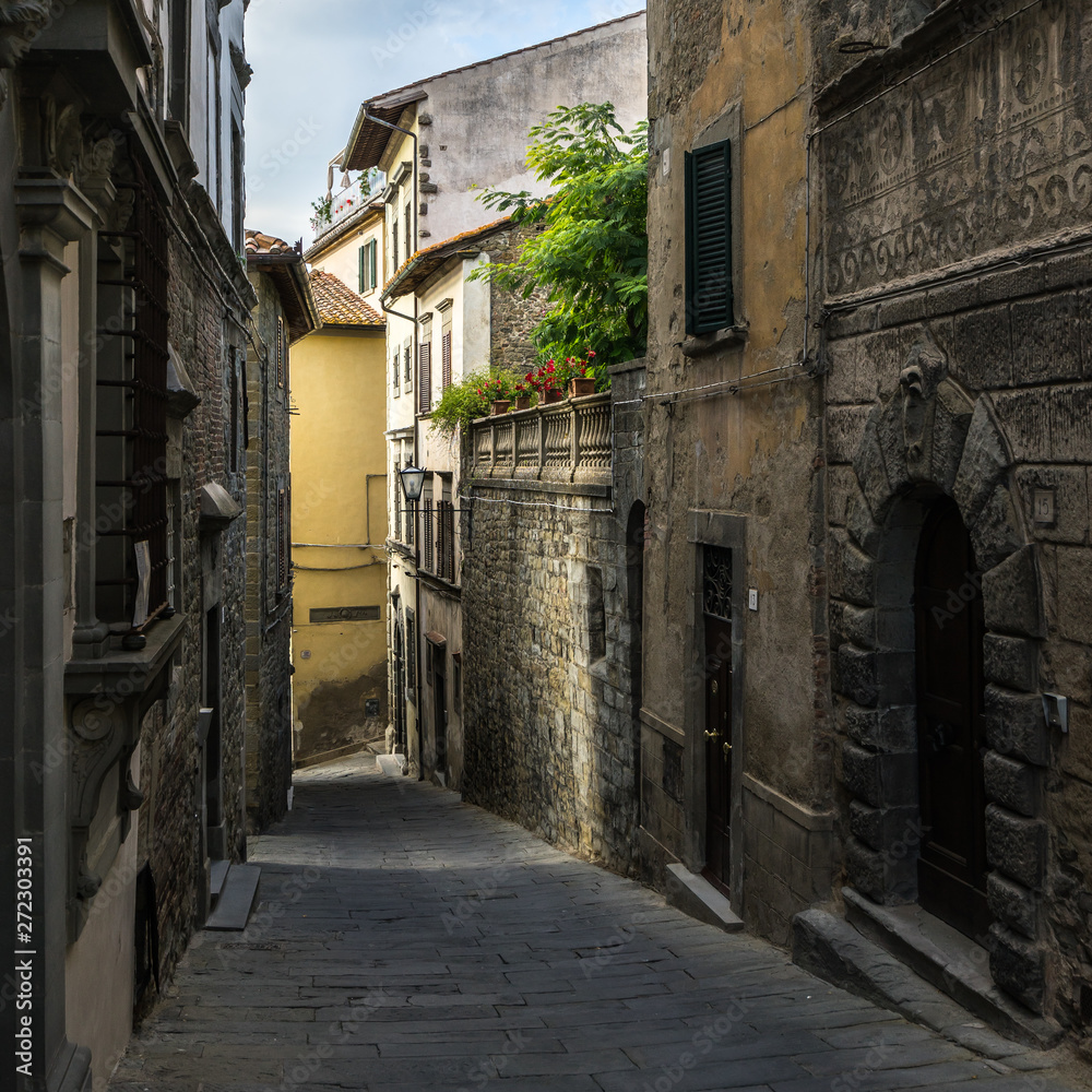 Fototapeta premium A typical narrow street in Cortona historic center. Cortona is a beautiful medieval town in Tuscany, Italy