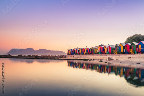 View of the beautiful sunset over False Bay from Kalkbay with little coloured houses on the beach, with mountains in the background, Cape Town, South Africa photo