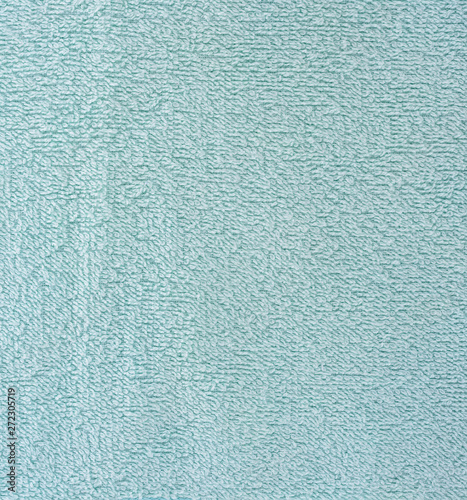 The texture of the fabric is light blue terry towel. Terry cloth as a background.