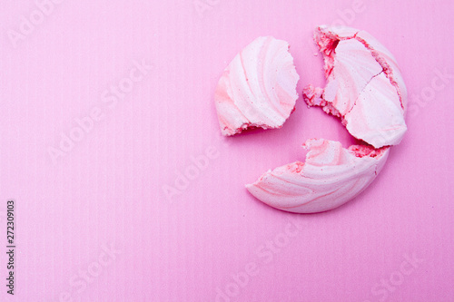 Pink meringues broken into pieces on a pink background. Culinary mistakes meringue concept photo