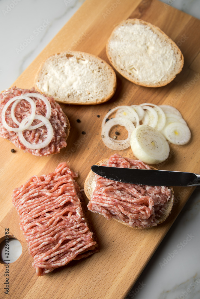 Deutsche Mettbrötchen mit rohen Schweine Mett, Brötchen, Butter, Zwiebeln, Pfeffer und Mett auf