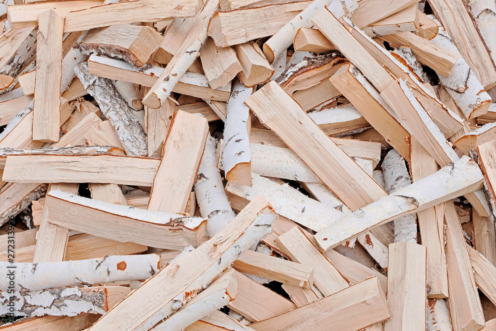 The concept of wood. Firewood chop. Natural raw material. The firewood is piled in a mess. Natural texture.