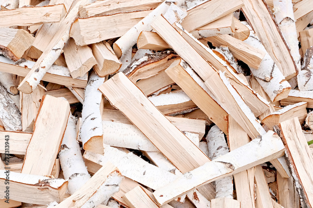 The concept of wood. Firewood chop. Natural raw material. The firewood is piled in a mess. Natural texture.