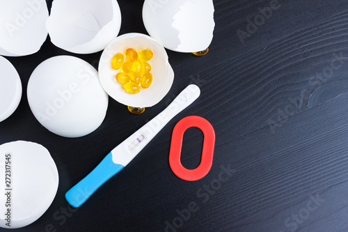 Infertility. Negative pregnancy test, pills, eggshell and number zero on black photo