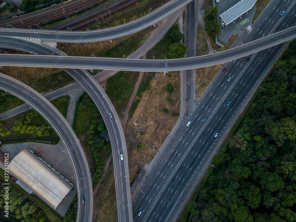 Road junction top view. Highways and forest. Traffic in the city. Aerial view