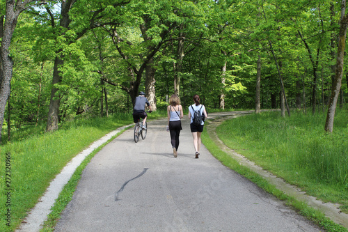 Older man an a bike passing two women on the North Branch Trail in Morton Grove  Illinois