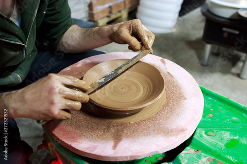 the master measures with a ruler the width of the plate, made to order from red clay. The product is made on a potter's wheel, on a sheet of chipboard for better removal and further drying. reportage.