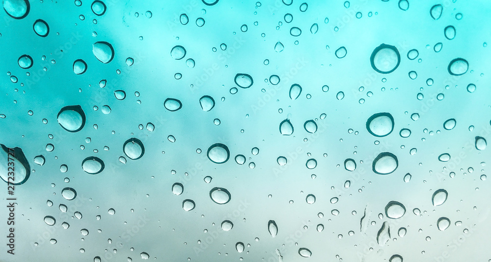 Water drops of rain on window with turquoise gradient Water drops of rain on window with turquoise gradient