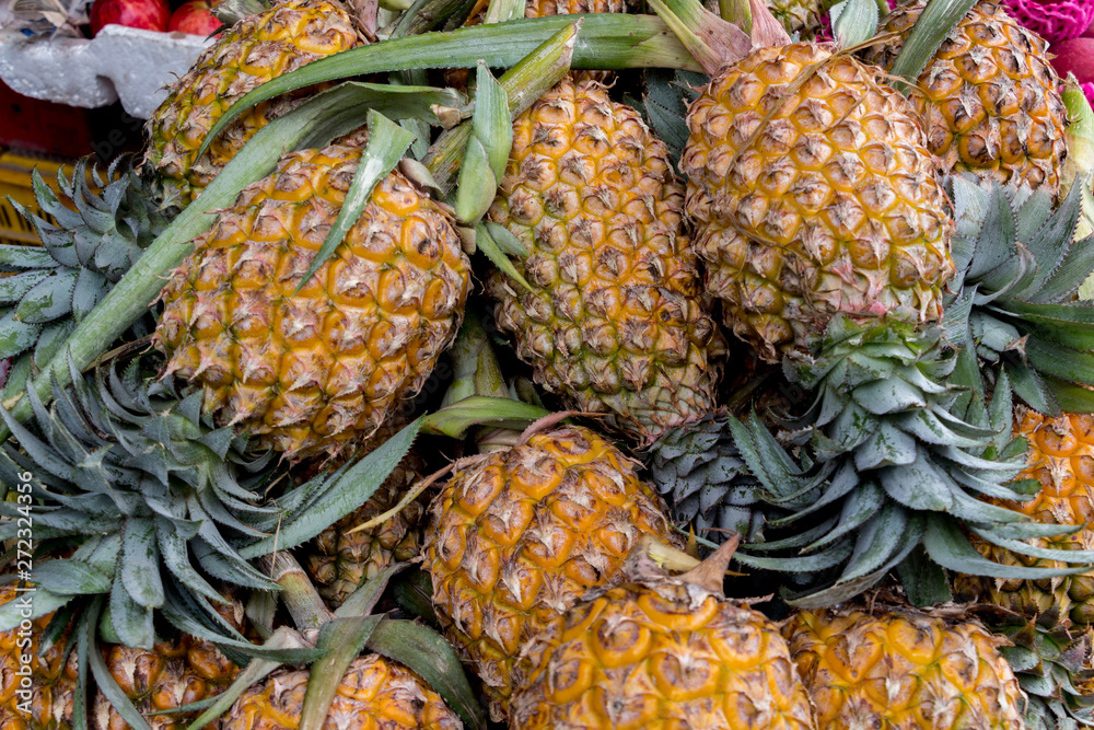 Fresh pineapples piled up in two lines at the market. Fruit scenery. Fresh fruit.