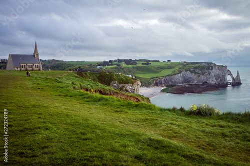 Etretat village in France. Couple nearby the church with the view to the sea © Alexey Oblov