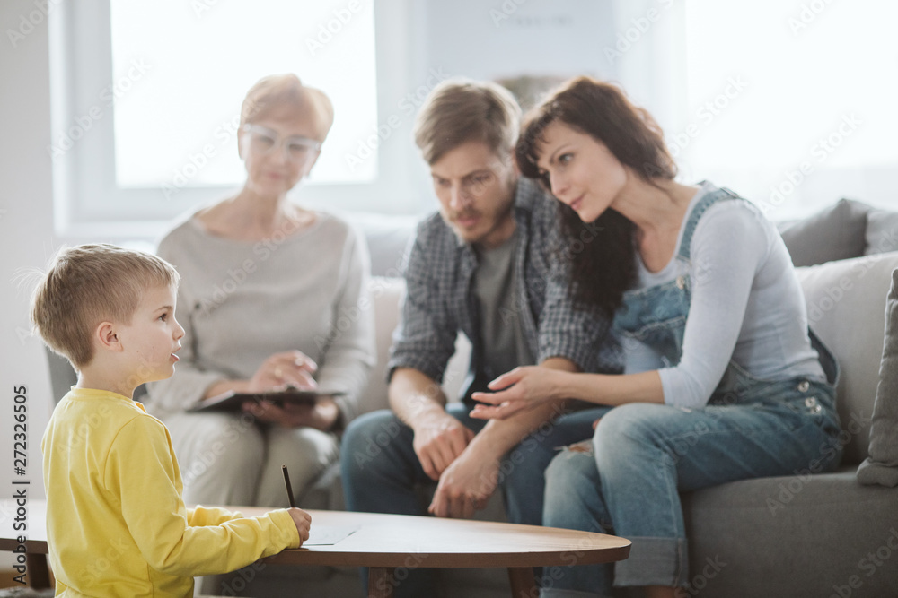 Young married couple with son during family therapy with counselor Young married couple with son during family therapy with counselor