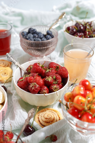 Summer berries strawberries, blueberries, sweet cherries in vases on the table. Top view