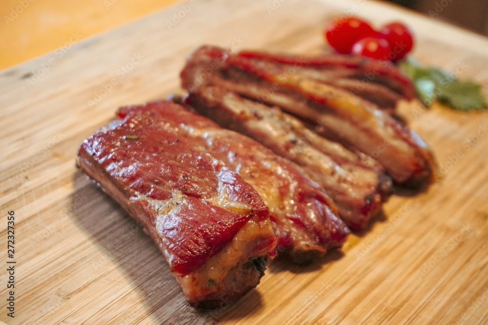 BBQ, Roasted pork ribs and delicious tomatoes, placed on a wooden tray. raw meat on a plate, BBQ, Roasted pork ribs and delicious tomatoes, placed on a wooden tray. raw meat on a plate,