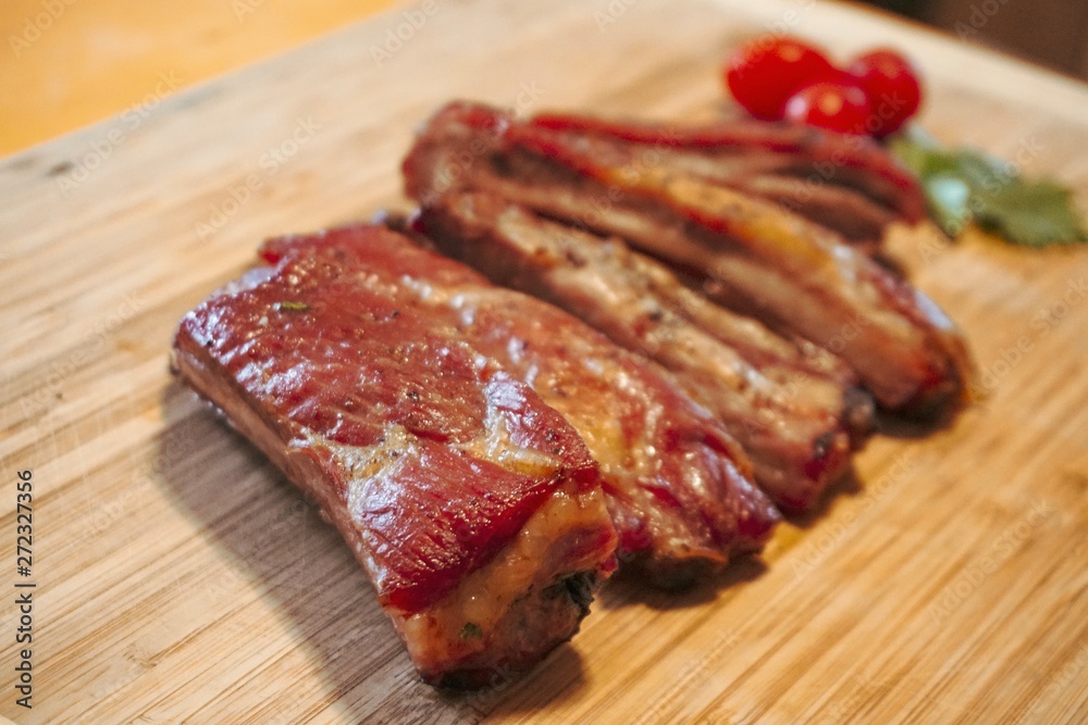 BBQ, Roasted pork ribs and delicious tomatoes, placed on a wooden tray. raw meat on a plate, 