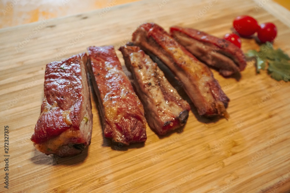 BBQ, Roasted pork ribs and delicious tomatoes, placed on a wooden tray. raw meat on a plate, 