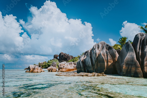 Famous granite boulders in lagoon with shallow ocean water and white cloudscape on amazing Anse Source D'Argent tropical beach, La Digue Seychelles. Luxury exotic travel concept photo