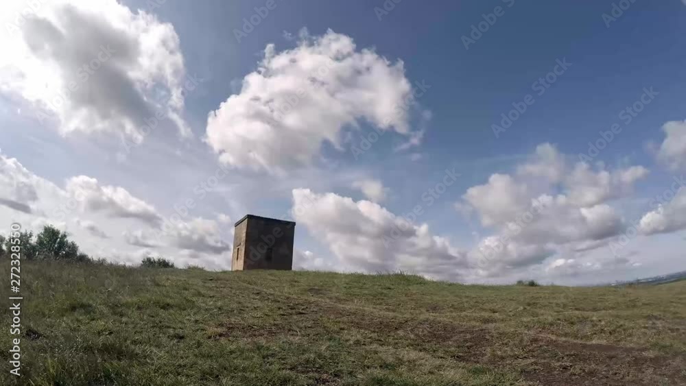 Clouds timelapse forming above old Billinge hill stone hillside structure on bright green grass English hillside. Clouds timelapse forming above old Billinge hill stone hillside structure on bright green grass English hillside.