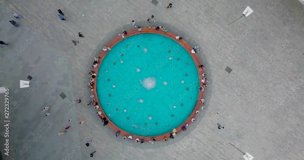 Top aerial Overhead beautiful fountain and sitting people around Top aerial Overhead beautiful fountain and sitting people around