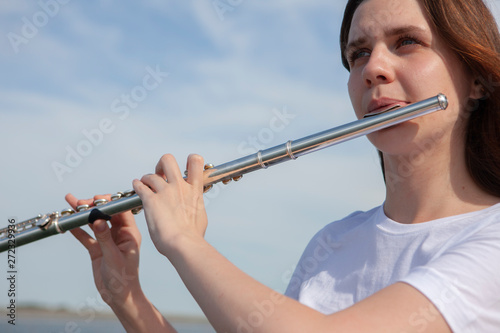 Fotografia, Obraz Beautiful woman playing flute in Waterfront Smiling woman.