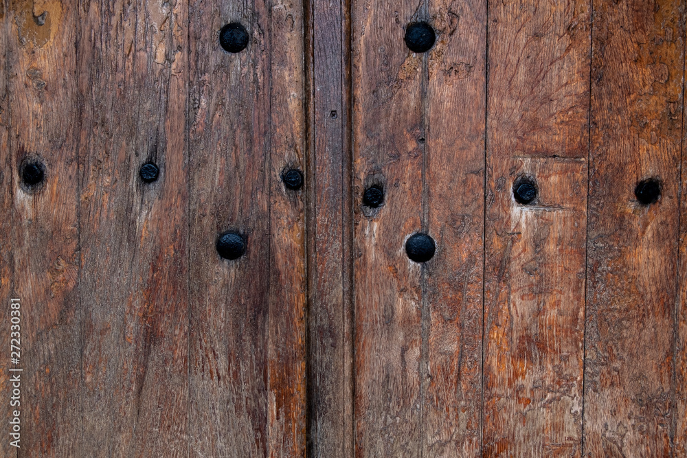 antique wooden door with black rivets. Rusty nails in an old wooden door. background - vintage tree. antique wooden door with black rivets. Rusty nails in an old wooden door. background - vintage tree.