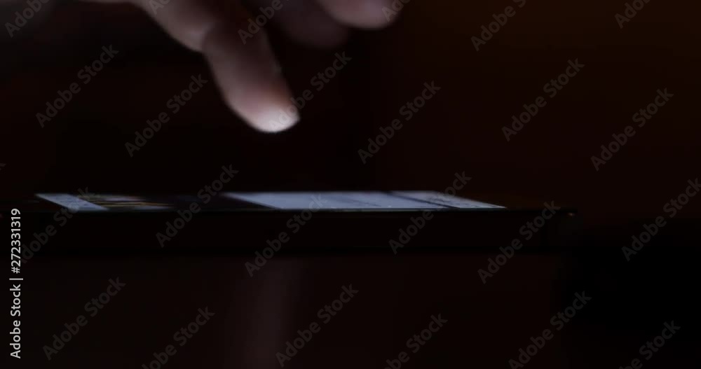 Scrolling through posts in social network on a smartphone at night - Internet addiction concept