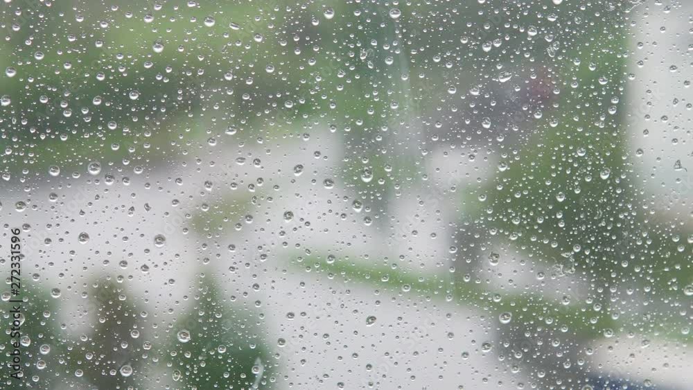 Drops on the window glass and city on the background. Left to right view Drops on the window glass and city on the background. Left to right view