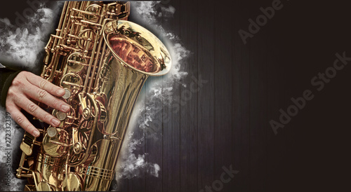 Photography Saxophone jazz music instrument with smoke clouds isolated on black wooden backg